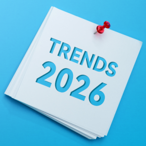 Stack of white papers pinned with a red pin reading 'TRENDS 2026' on a bright blue background.